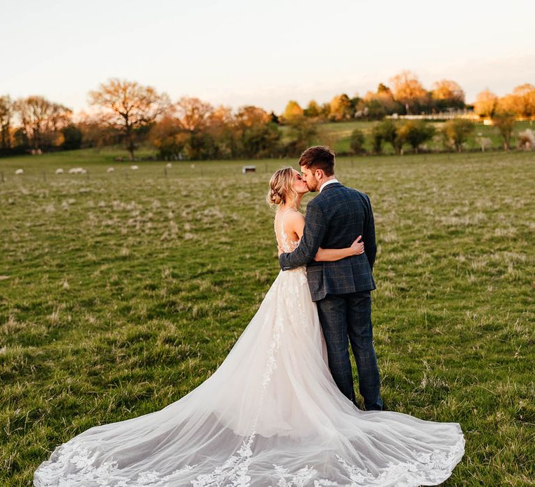 Bride and groom share a kiss as they pose for their couple portraits 