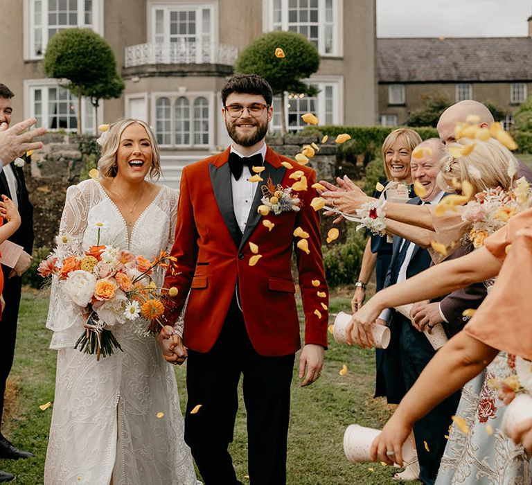 Bride and groom have confetti exit to yellow rose petals 