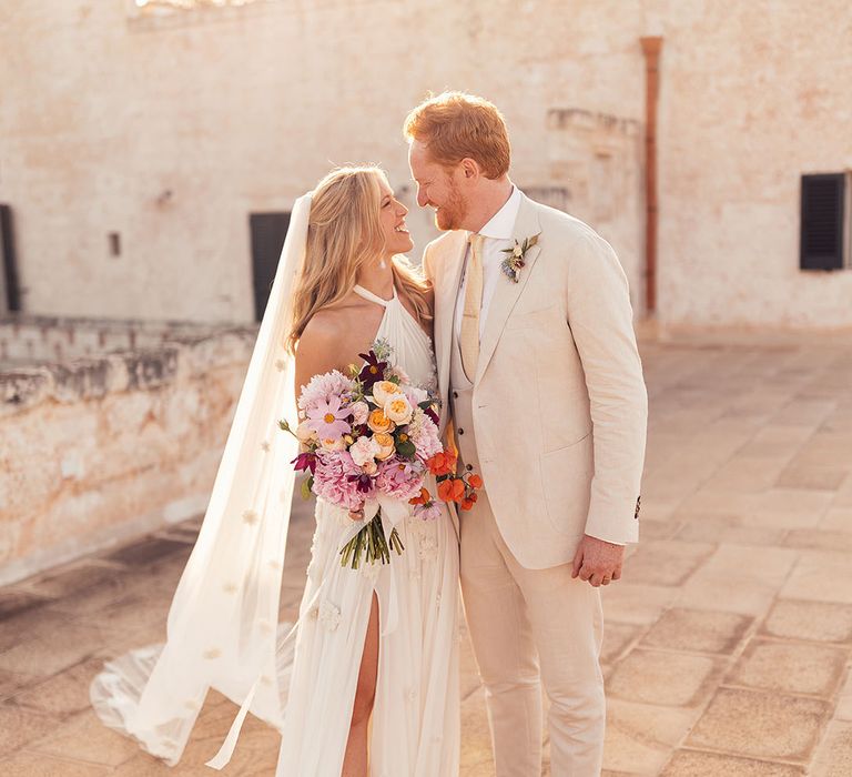 Bride and groom smile and look into each other's eyes for their relaxed rustic wedding in Italy 