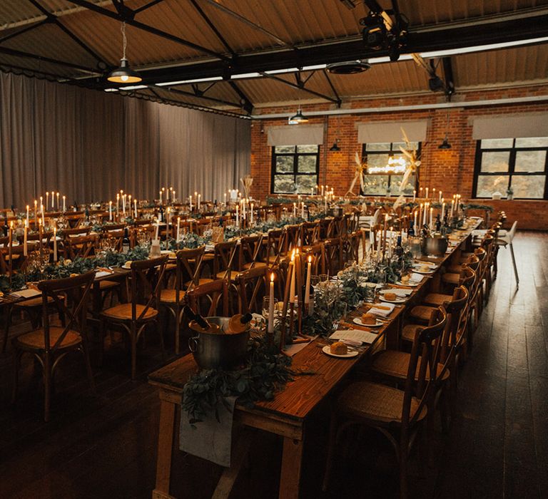 Wooden banquet tables complete with green foliage table runners at the Venue Bowers Mill