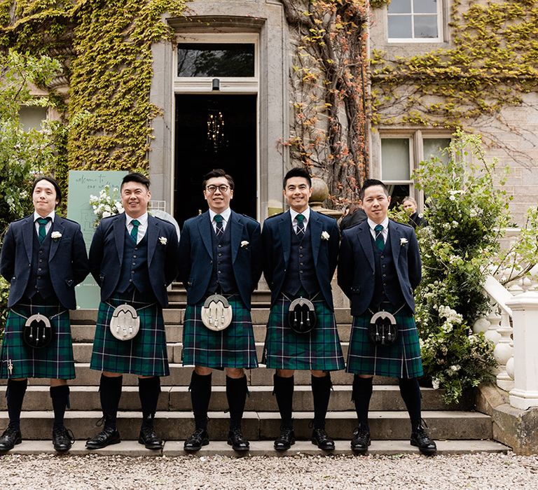 Groom and his groomsmen wear tartan green kilts for Carlowrie Castle wedding 