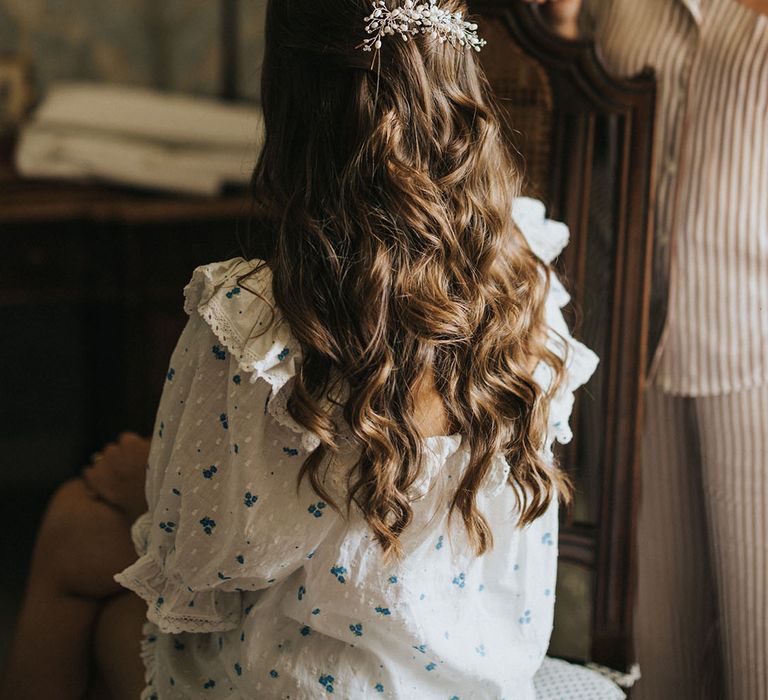 Bride with curled brown half up half down wedding hair with silver and pearl wedding hair accessory 