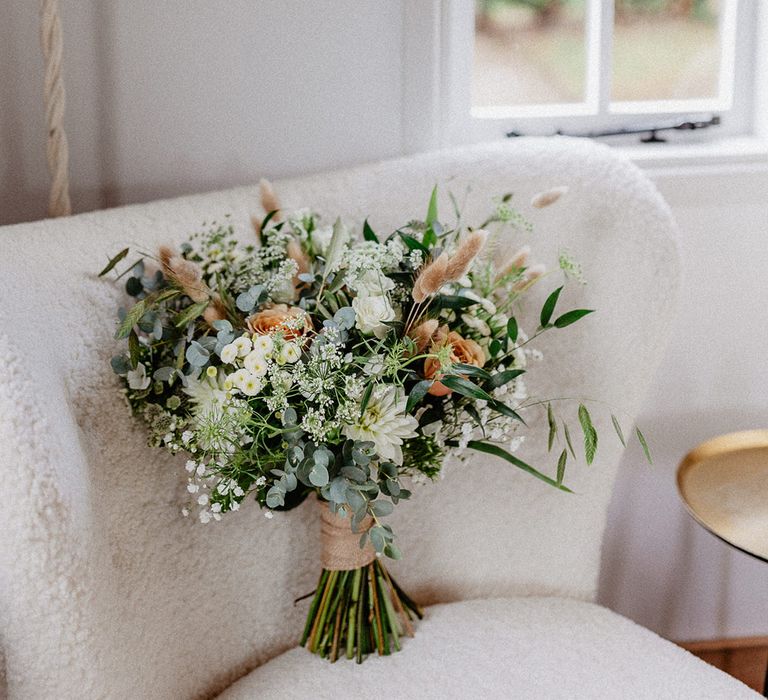 Bunny grass, gypsophila, and eucalyptus leaves in the bridal bouquet for rustic barn wedding in Hampshire 