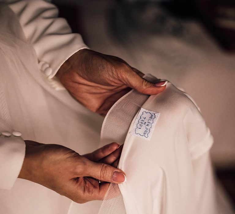 Bride wearing a layered wedding dress with personalised label with the bride, groom and their son's names