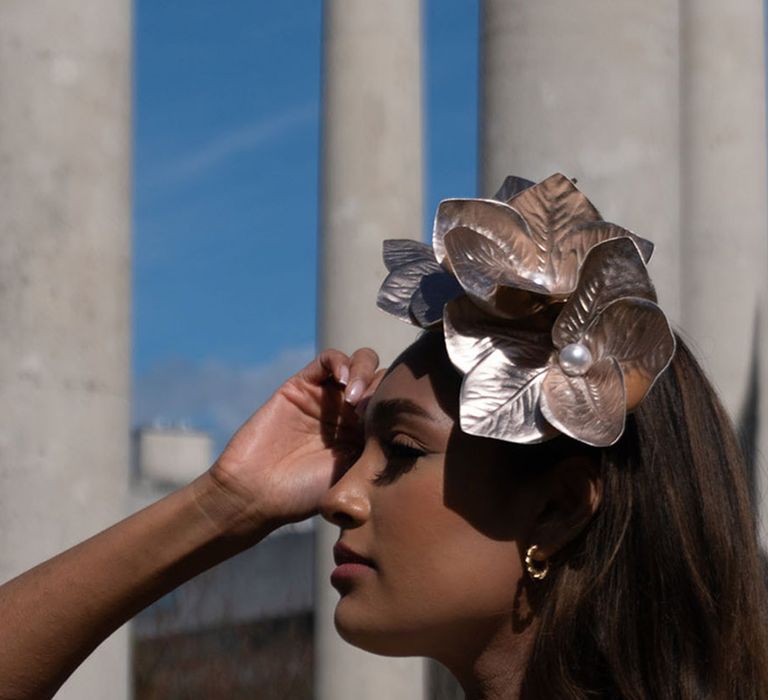 Bride wearing statement gold flower wedding hair accessory 