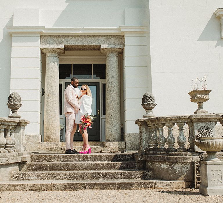 Pink wedding theme for Polstrong Manor wedding with the bride in a puff sleeve wedding dress and groom in pink suit 