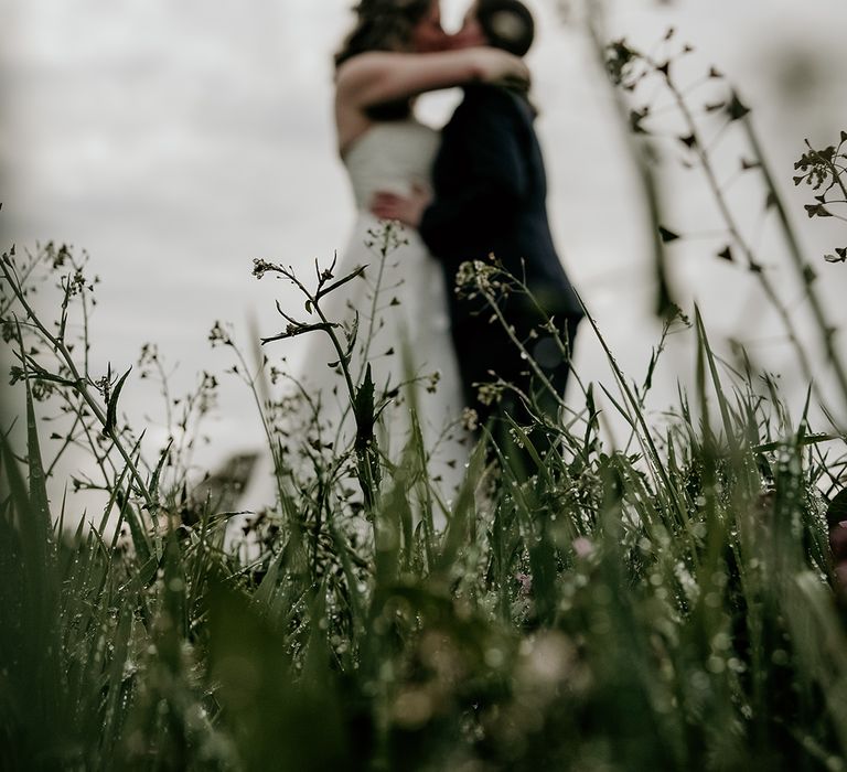 couple kissing in a field at Stanford farm wedding 