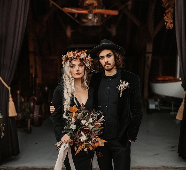 Halloween wedding with groom in all black wedding outfit and hat groom accessory 