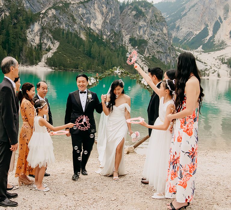 The family throw confetti over the bride and groom at their wedding ceremony 