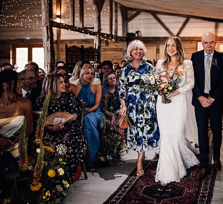 The Cherry Barn in Rye wedding venue with the bride walking down the aisle with her parents 