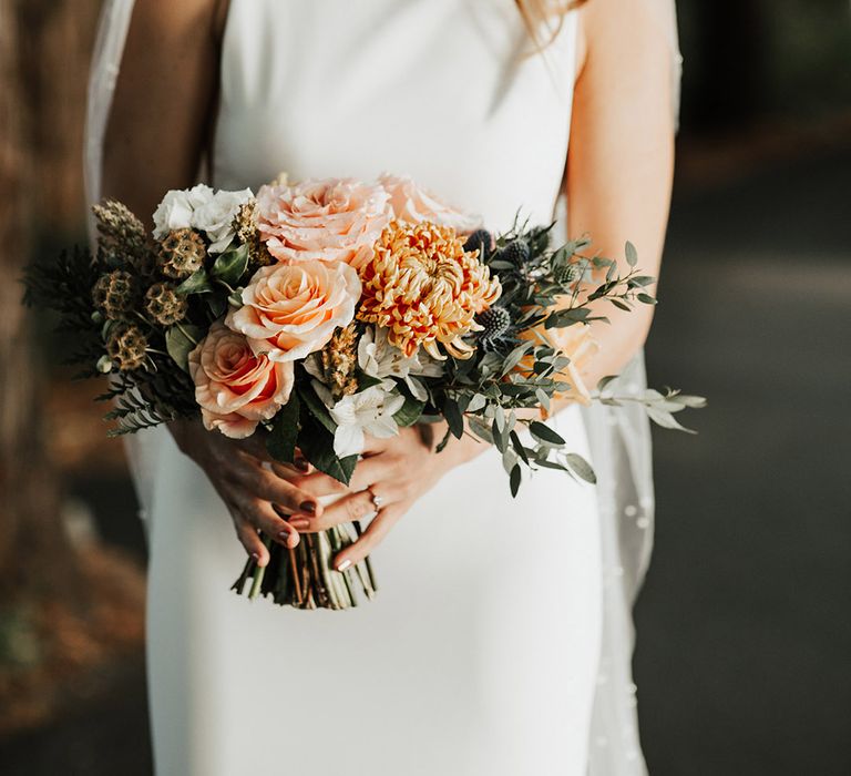 Thistles, roses, and dahlias with peach, white and pink tones