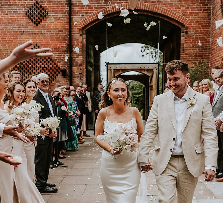 Classic white petal confetti moment for the bride and groom at Shustoke Barns in Warwickshire 