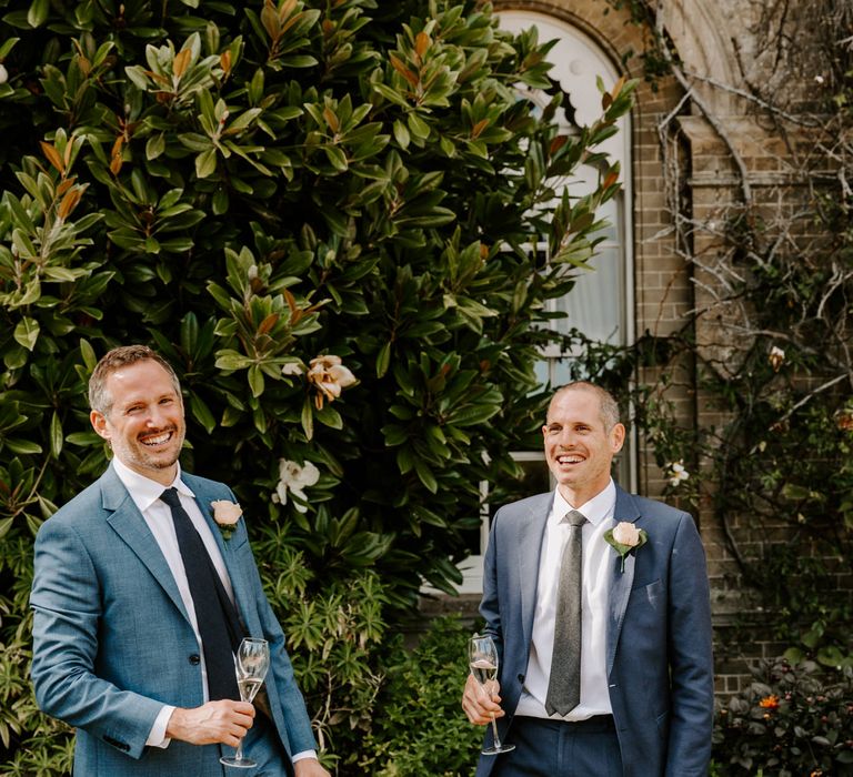 Groomsmen laughing in blue suits 