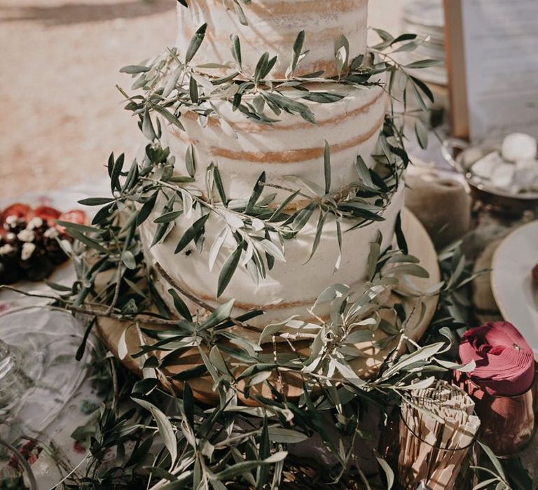 Three tier naked wedding cake with olive leaves