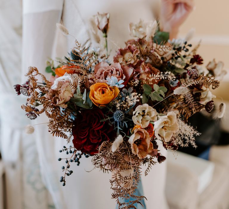 Close up of a bouquet in a wedding with Christmas church wedding flowers. Tied with a blue ribbon.