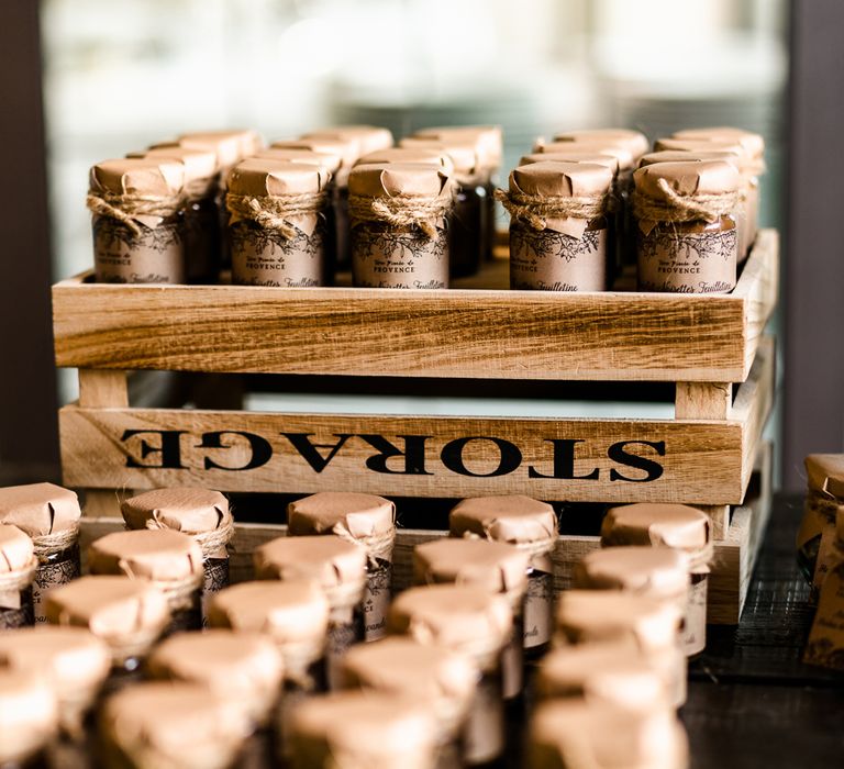 Jam jars are wrapped in brown paper and displayed in a crate. Photography by John Barwood.