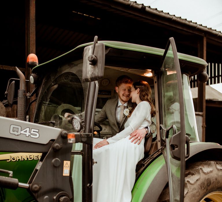 The bride and groom in a tractor on the groom's family farm