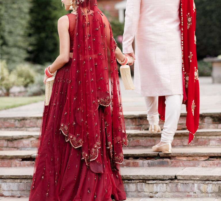 Bride & groom walk up the stairway outdoors on their wedding day