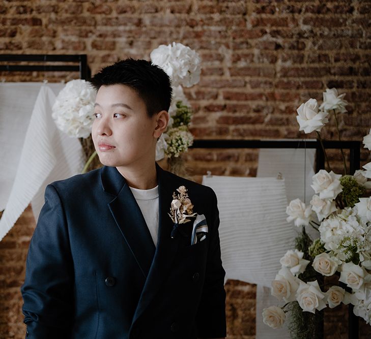 Asian Lesbian bride in a white t-shirt and navy suit jacket 