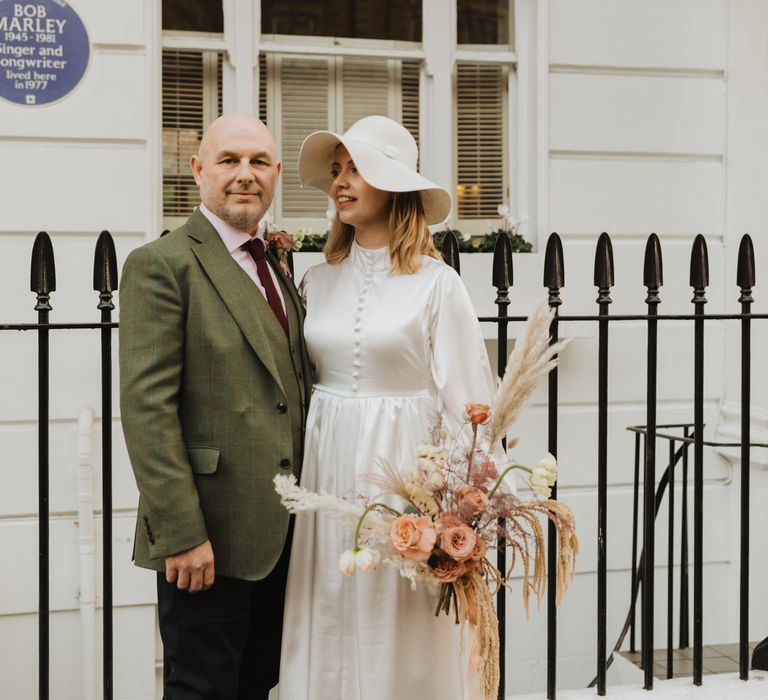 Bride & groom stand in front of black iron gate during wedding day