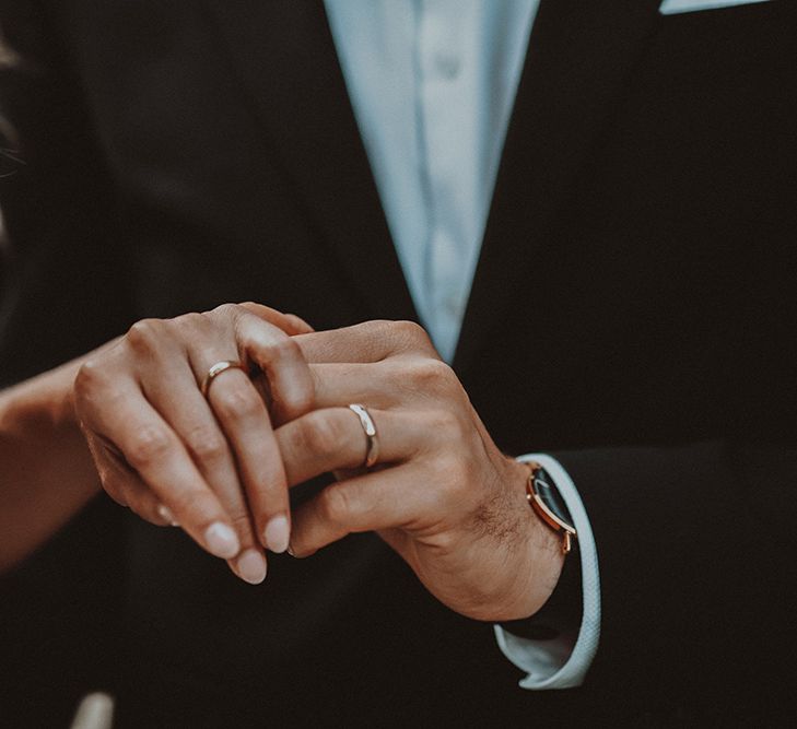 Bride and groom holding hands showing their wedding bands at intimate Gas Street Church wedding 