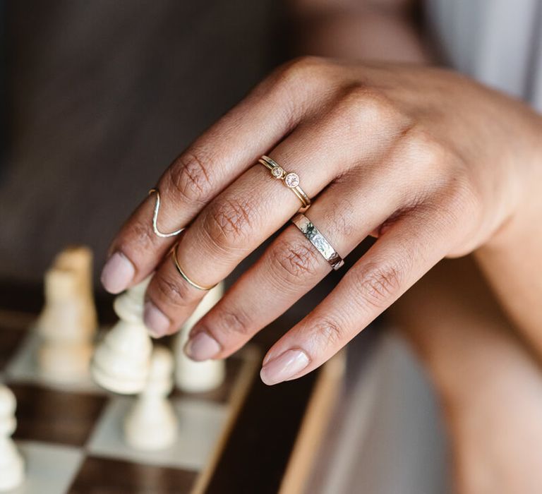 Woman wearing various wedding rings made by Nikki Stark