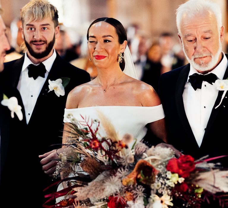 Bride winks at groom as she arrives at the altar