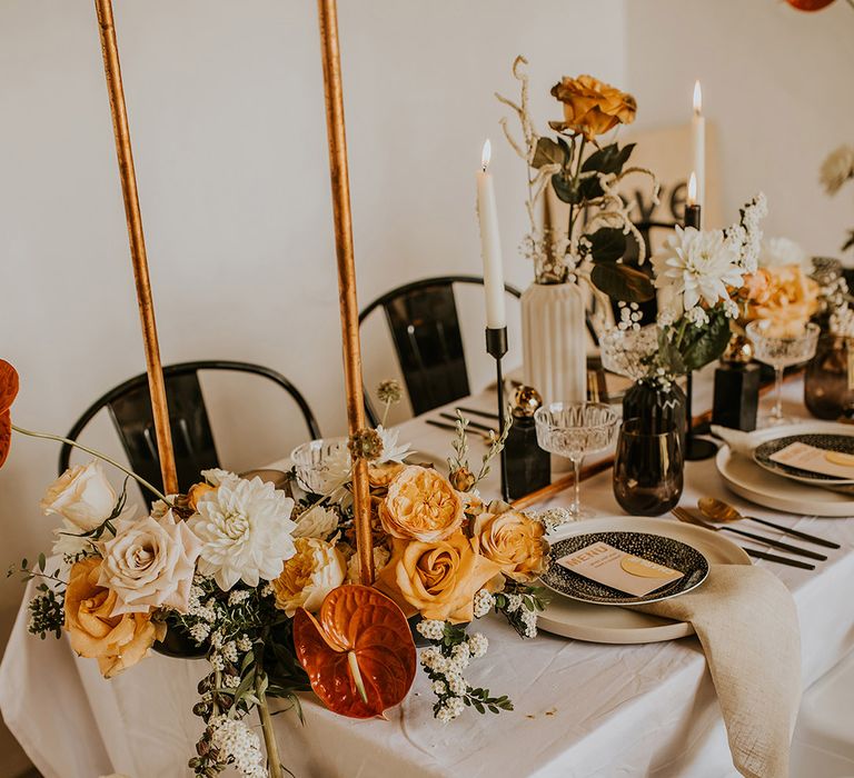 White dahlias, yellow roses and orange anthurium wedding flower arrangement at contemporary wedding at Curdshall Barn in Norfolk 