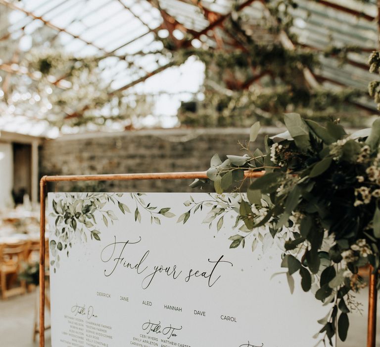 Beautiful table plan at wedding on copper stand