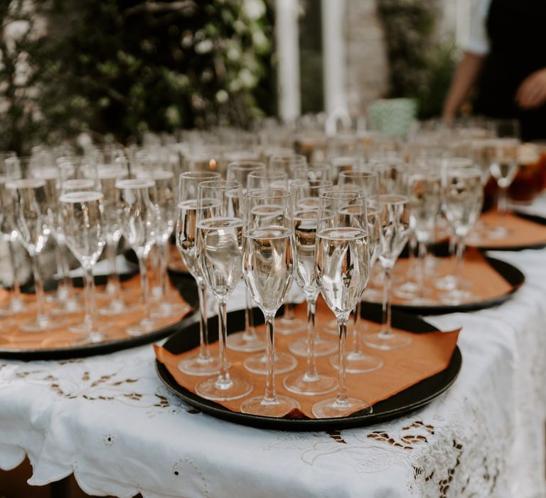 Trays of champagne flutes filled with sparkling wine at garden wedding in Bedfordshire