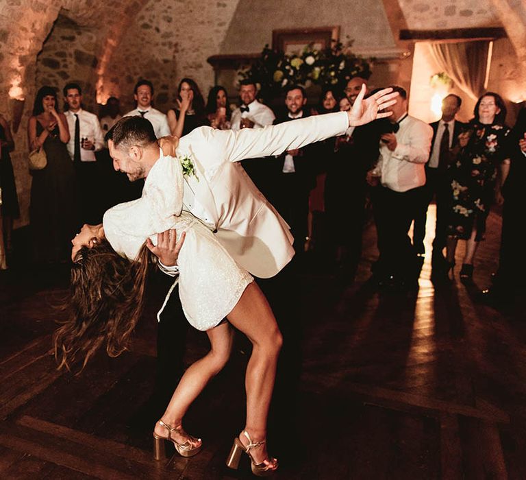 Groom dips his bride whilst dancing on their wedding day