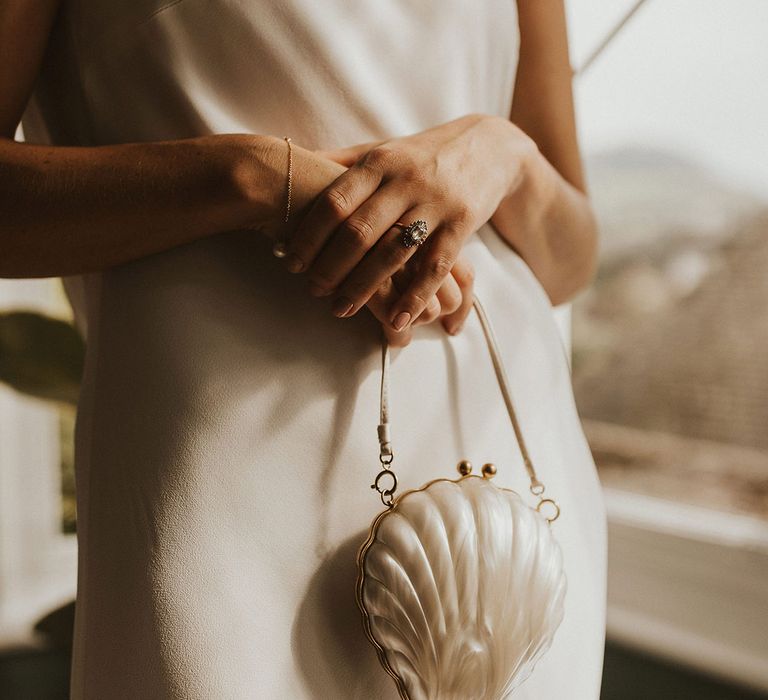 Bride holding a Lulu Guinness shell clutch bag bridal accessory 