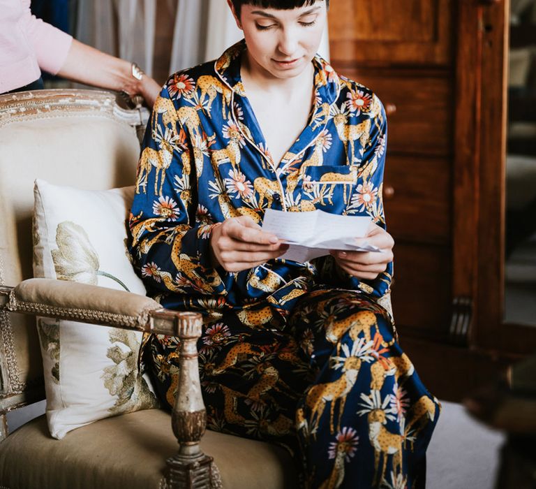 Bride with short brown hair in dark blue satin pyjamas on the wedding morning 