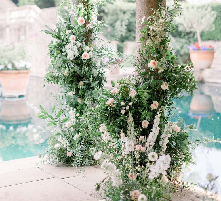 Green foliage outdoors complete with pastel florals against pillars 