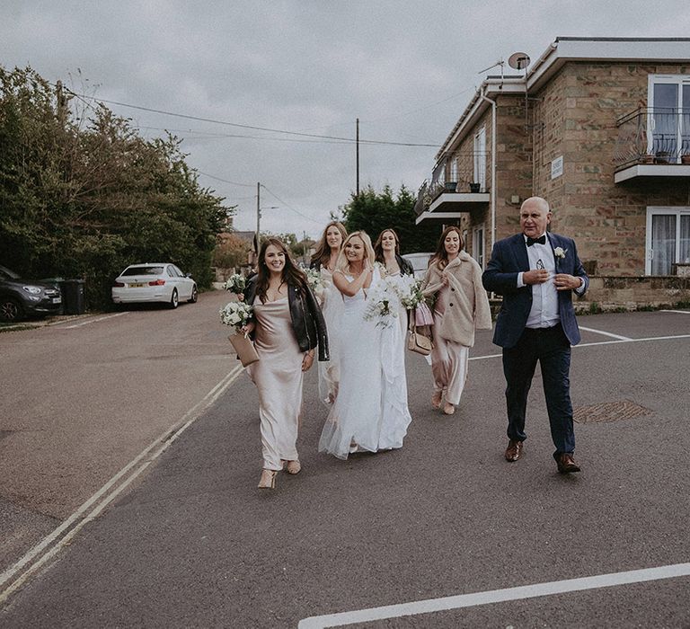 Bride makes her way to wedding with bridal party