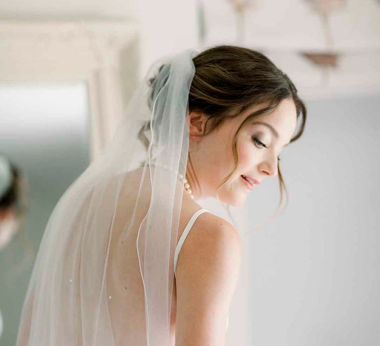 Bride wears floor length veil 