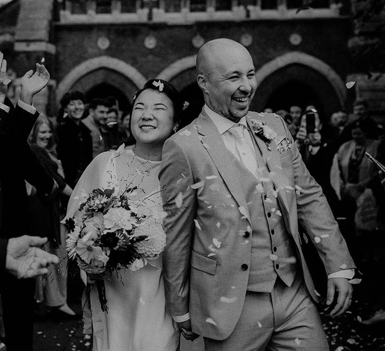 Bride & groom leave wedding ceremony as wedding guests throw confetti around them | Irene Yap Photography