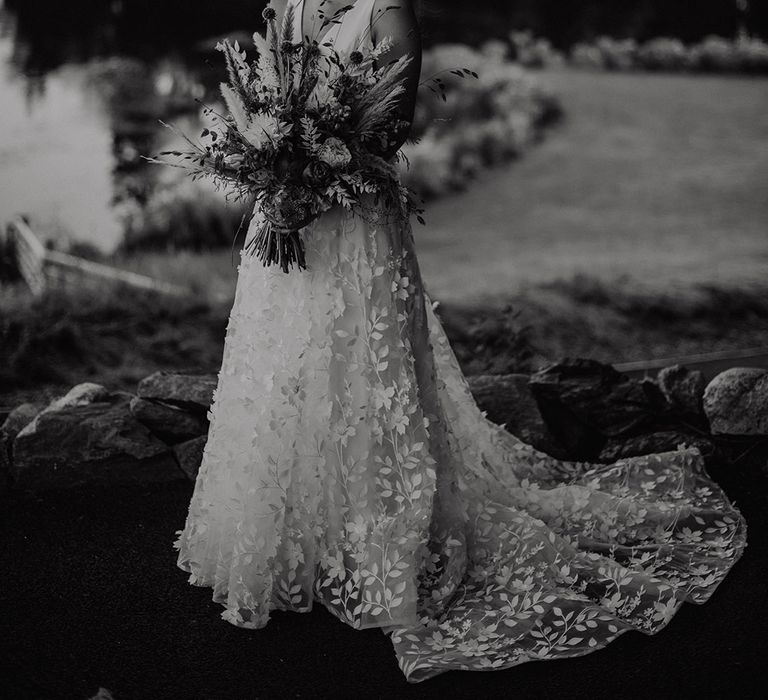 Bride in flower lace skirt wedding dress from Savin London holding large pampas grass autumnal wedding bouquet