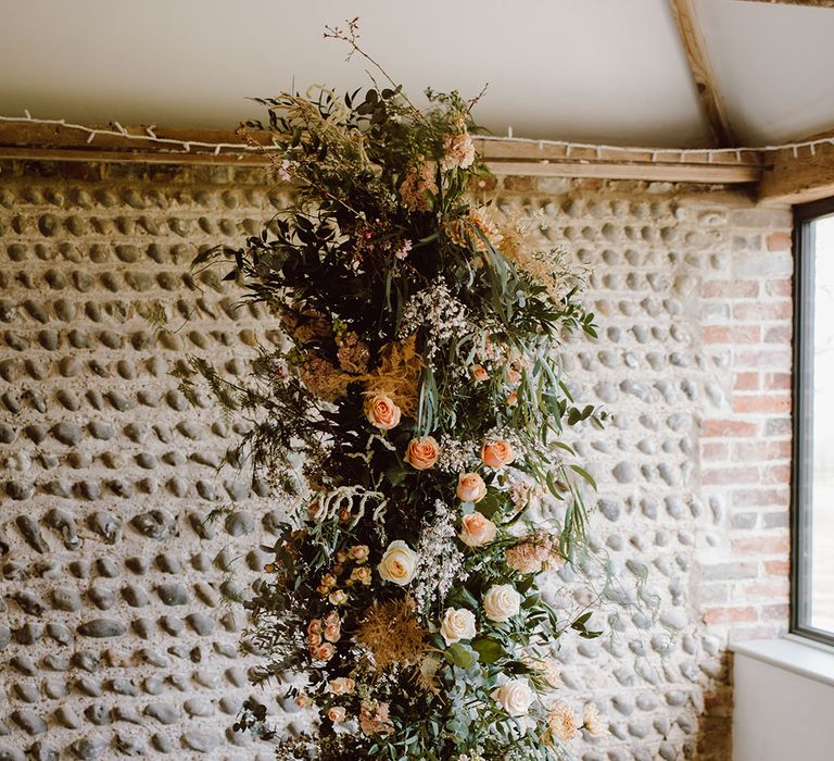 Altar column wedding flower arrangement with blush pink and peach flowers ad foliage 