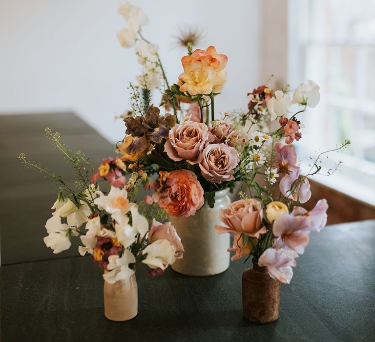 Pastel floral bouquets on wooden table for Spring wedding at Aswarby Rectory 