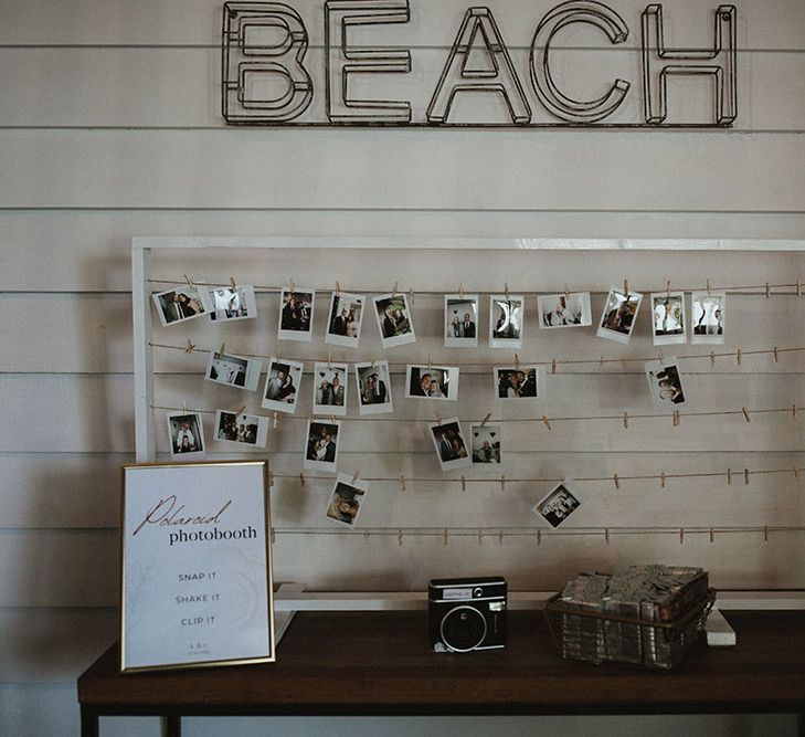 Polaroid photobooth with white frame and string to hang photo from 