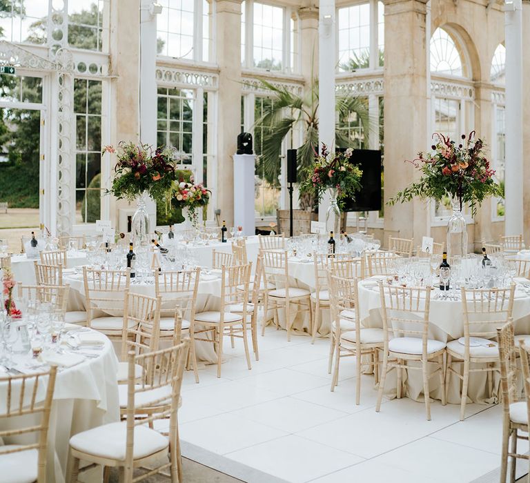 The Great Conservatory reception at Syon park, complete with clean tablescape styling and large bright floral centrepieces 