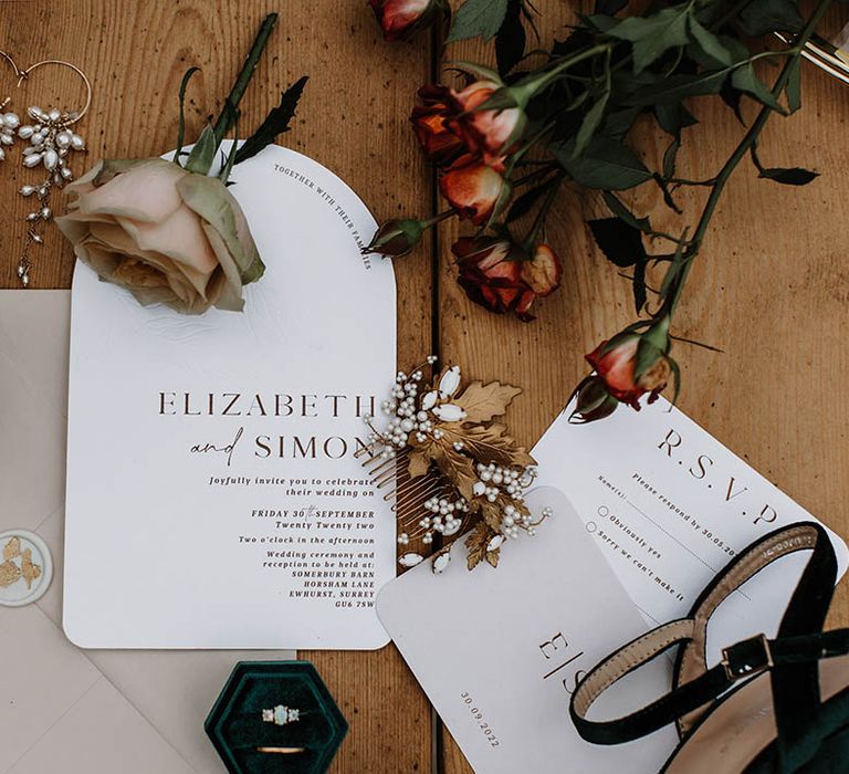 Neutral, white and black minimal wedding stationery with roses and green velvet ring boxes holding the engagement and wedding rings 