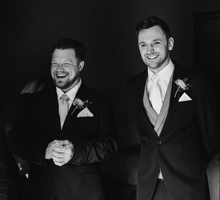 Groom and groomsmen in black three piece suit 