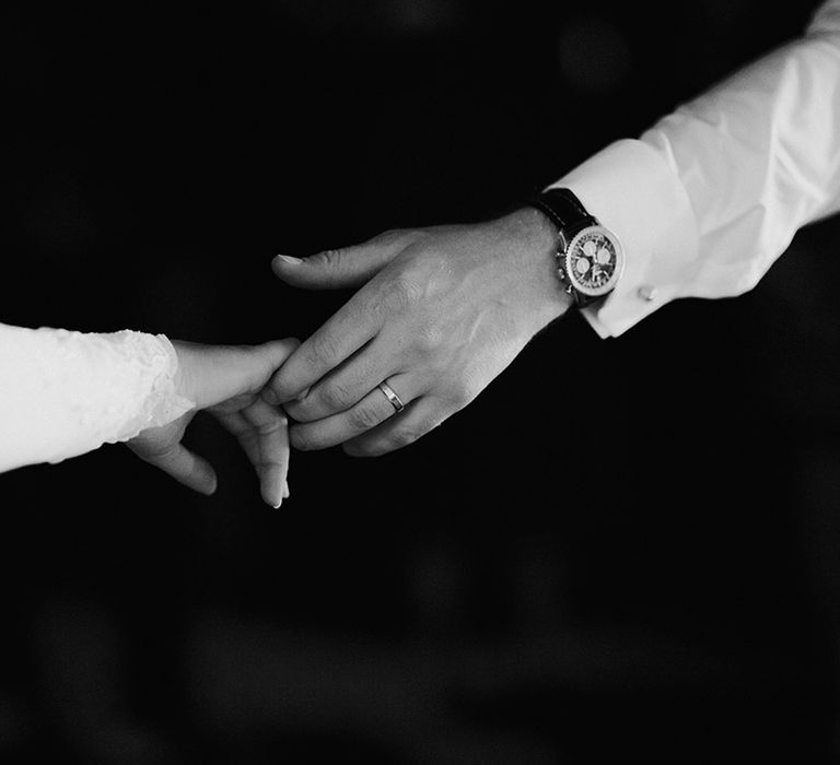 Bride and groom reading out and holding hands 