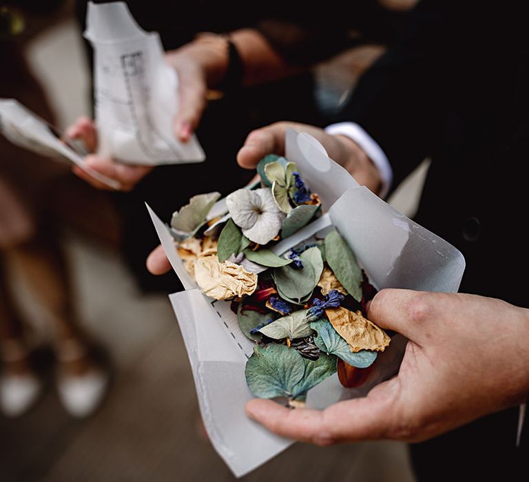 Dried wedding confetti with colourful florals and green leaf 