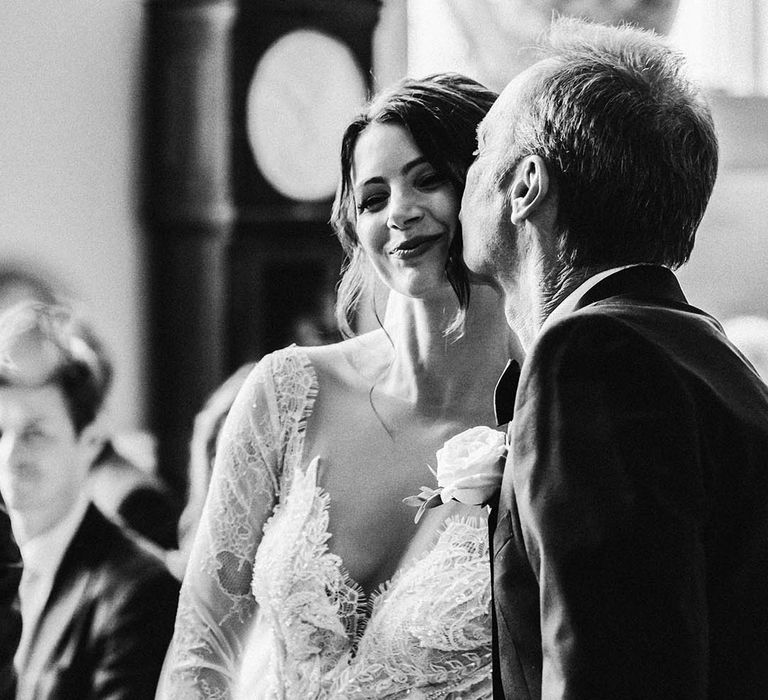 Father of the bride gives her a kiss on the cheek for the classic country house wedding 