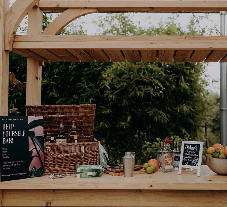 Help Yourself Bar with a basket of alcohol, citrus fruits, fresh water and a beer barrel