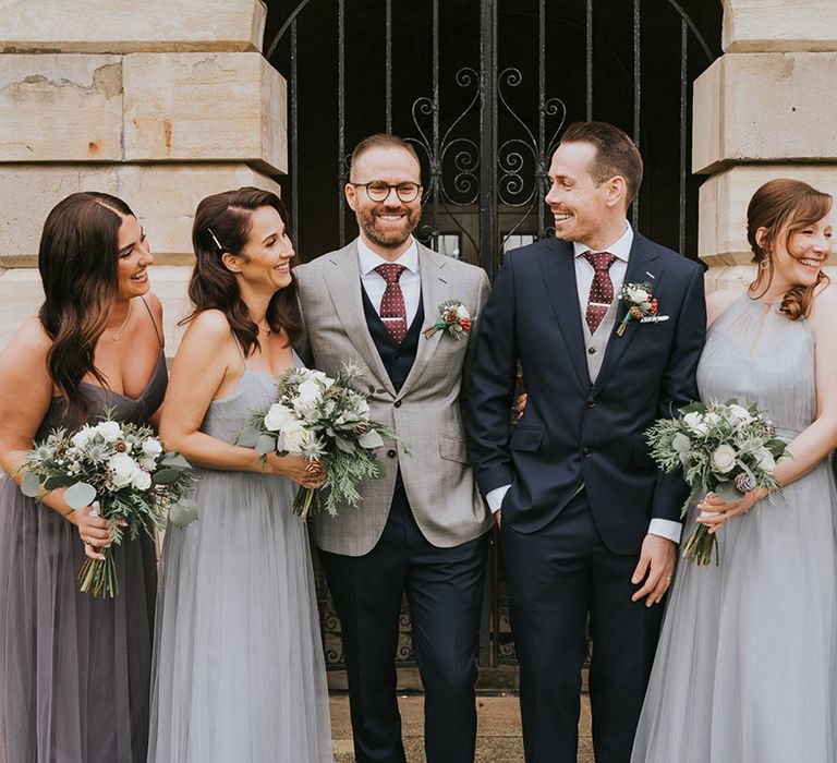 Bridesmaids in grey dresses with the groom in navy suit and groom in grey suit 