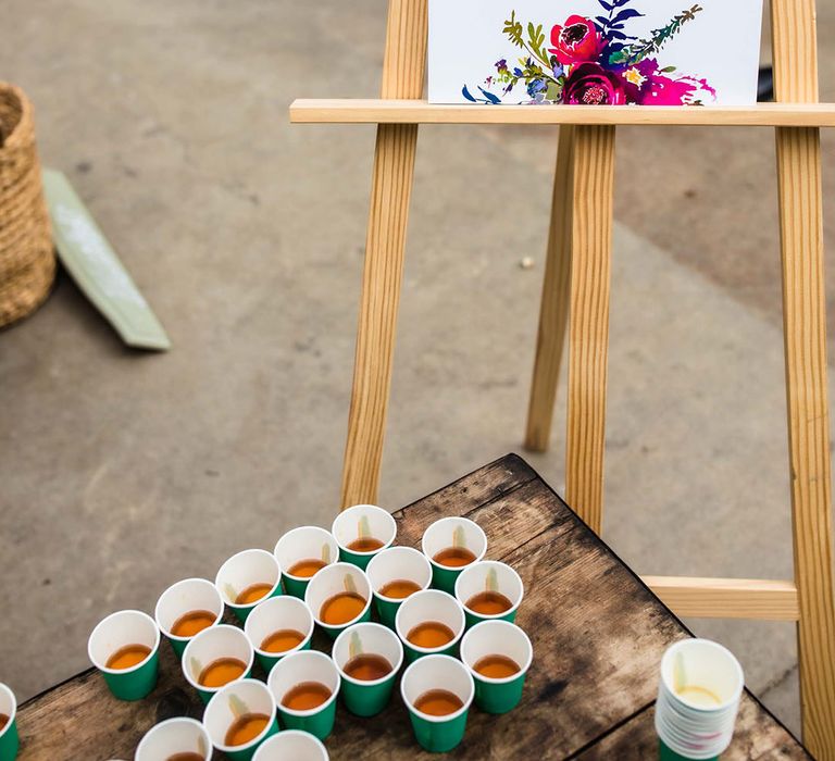 Shot station complete with floral illustrated wedding sign on wooden easel 